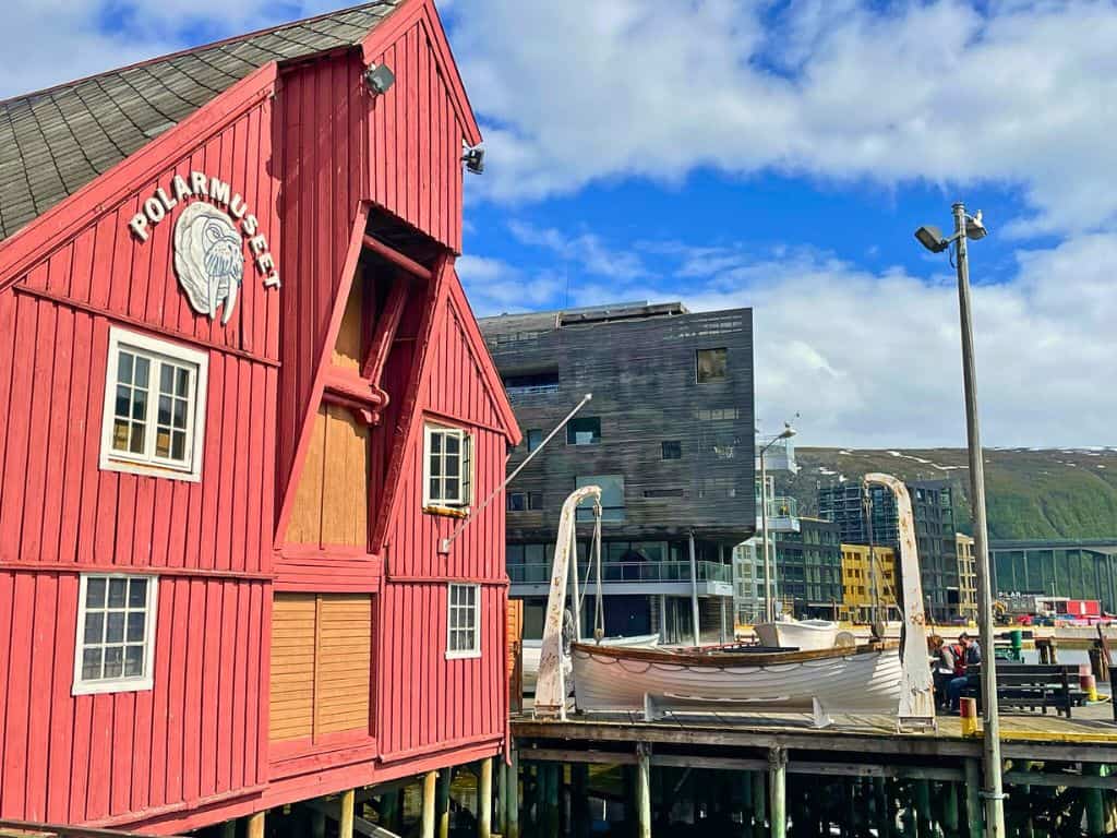 Red building of the outside of the Polar museum.  Downtown Tromso is in the background.
