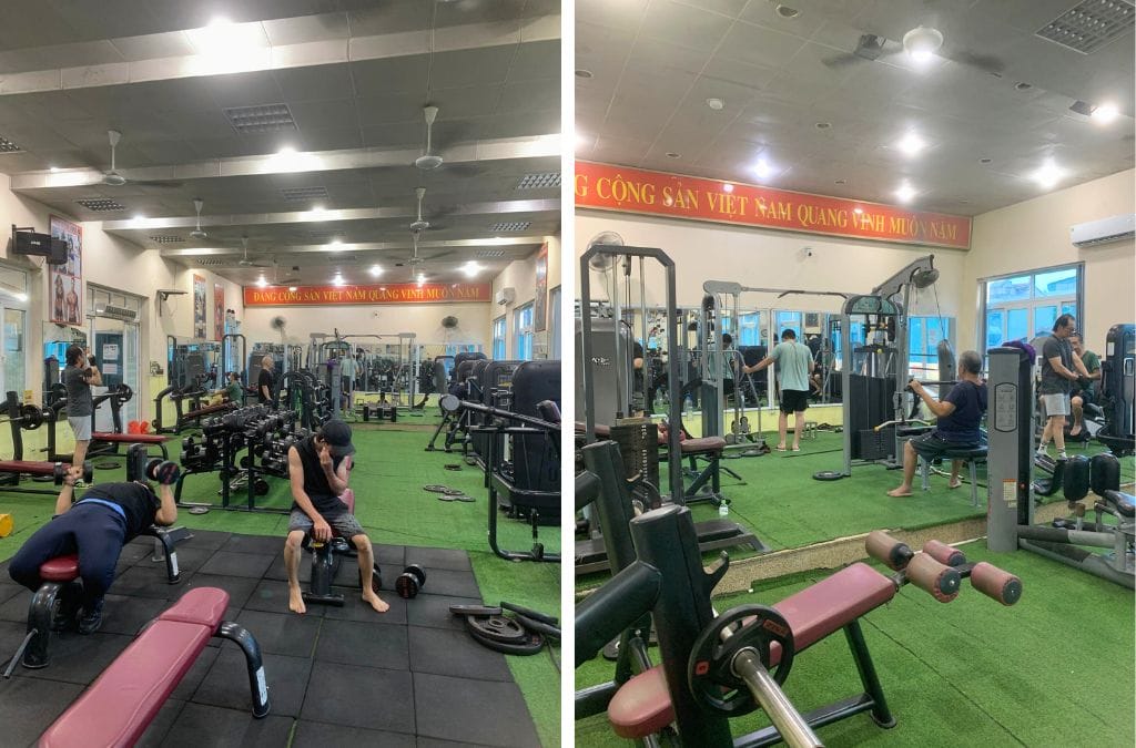 Two photos inside the X-Men Gym in Hanoi showing two view of one end of the gym. There's a lat-pull down, benches, and free weights (dumbbells)