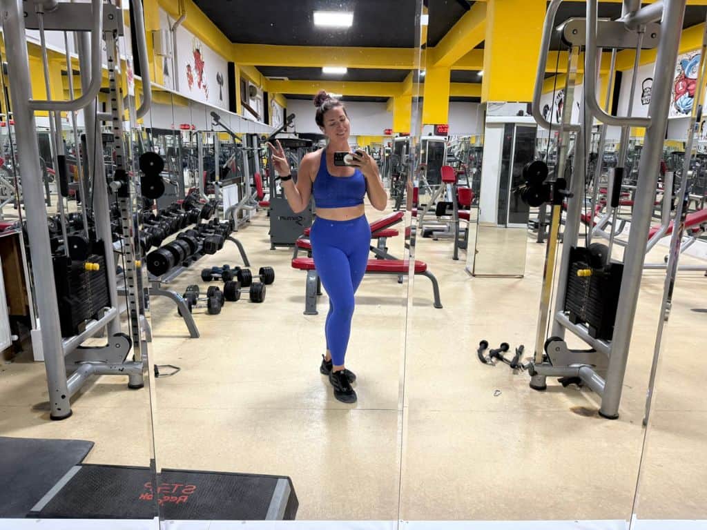 Heidi, the author, posing and smiling in the mirror at Goreme Fitness Center gym