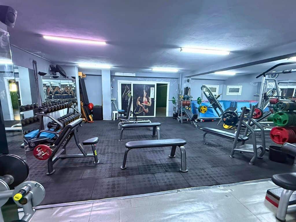 Side view of main lifting area with barbells and dumbbells