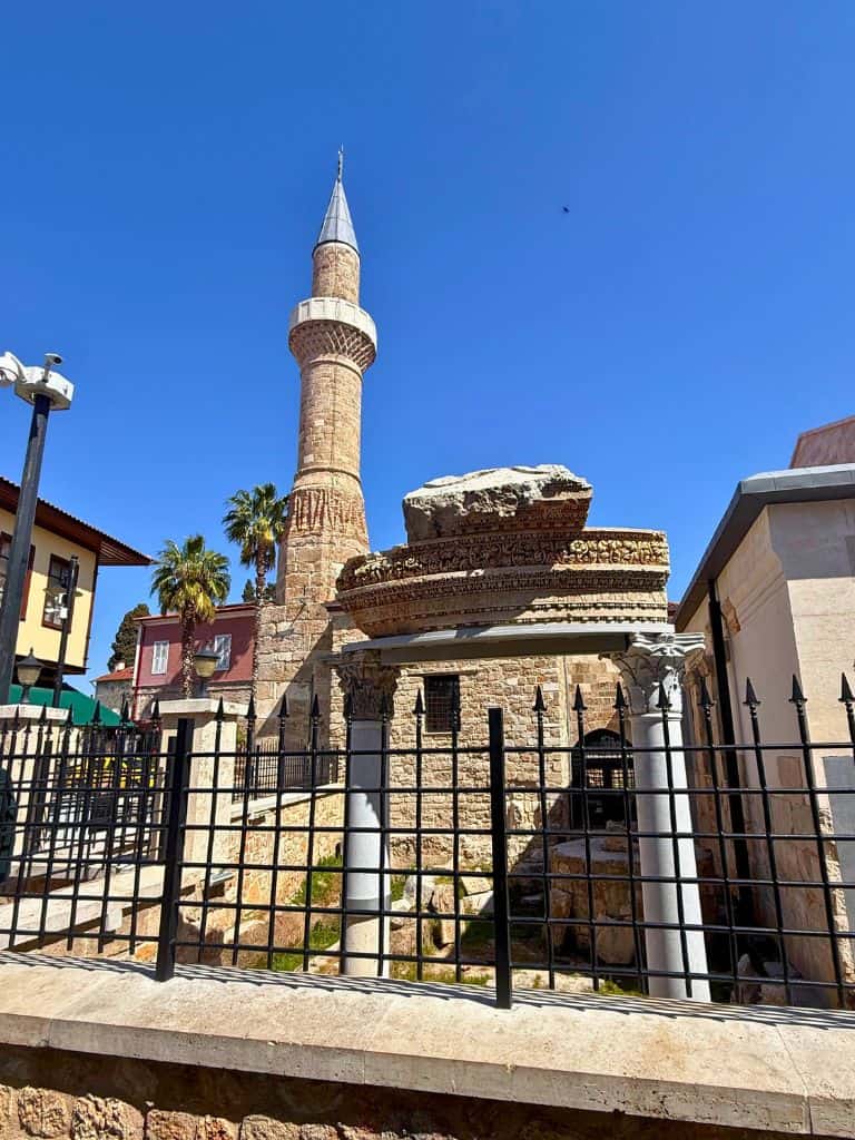 Renovated "broken" minaret behind an old archway of ruins in Antalya, Turkiye