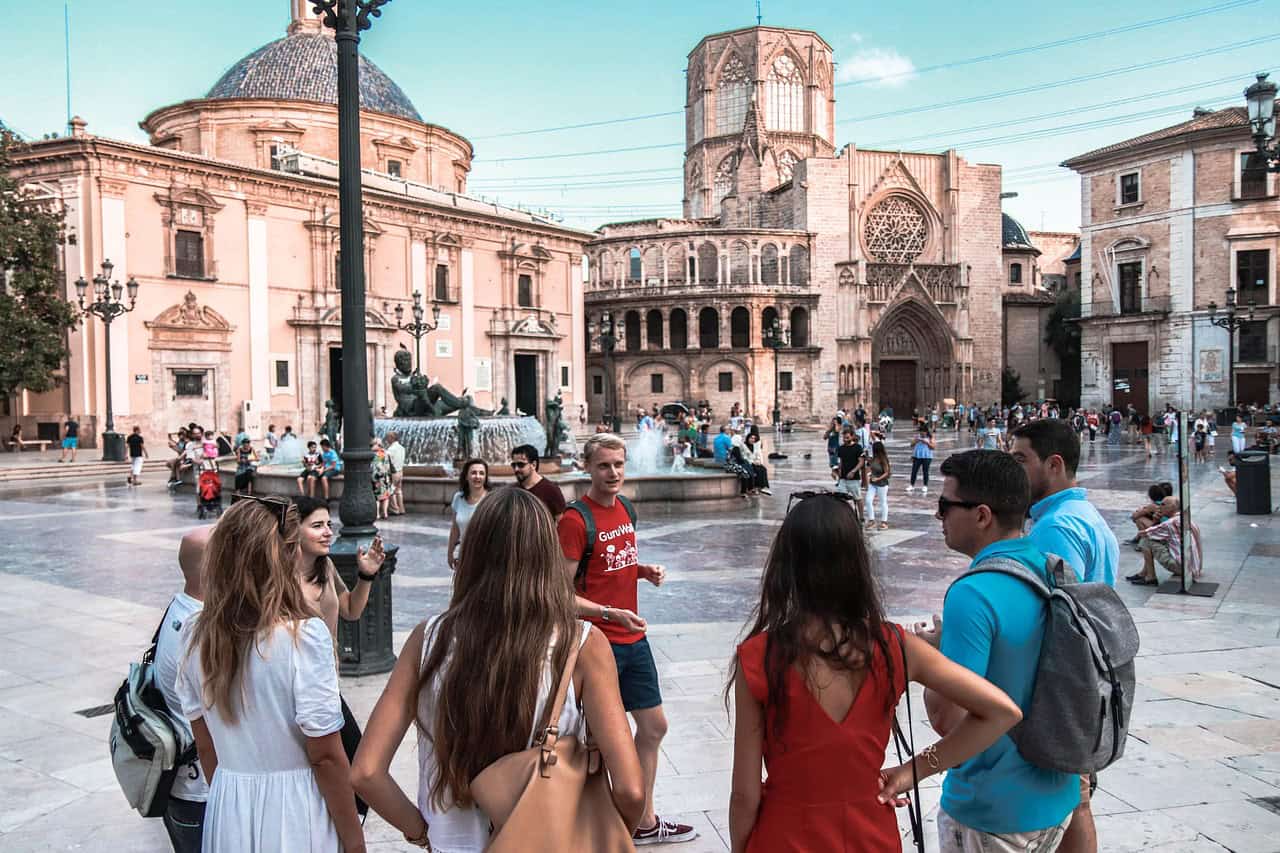 In person walking tour showing a guide with a group of tourists visiting a main square