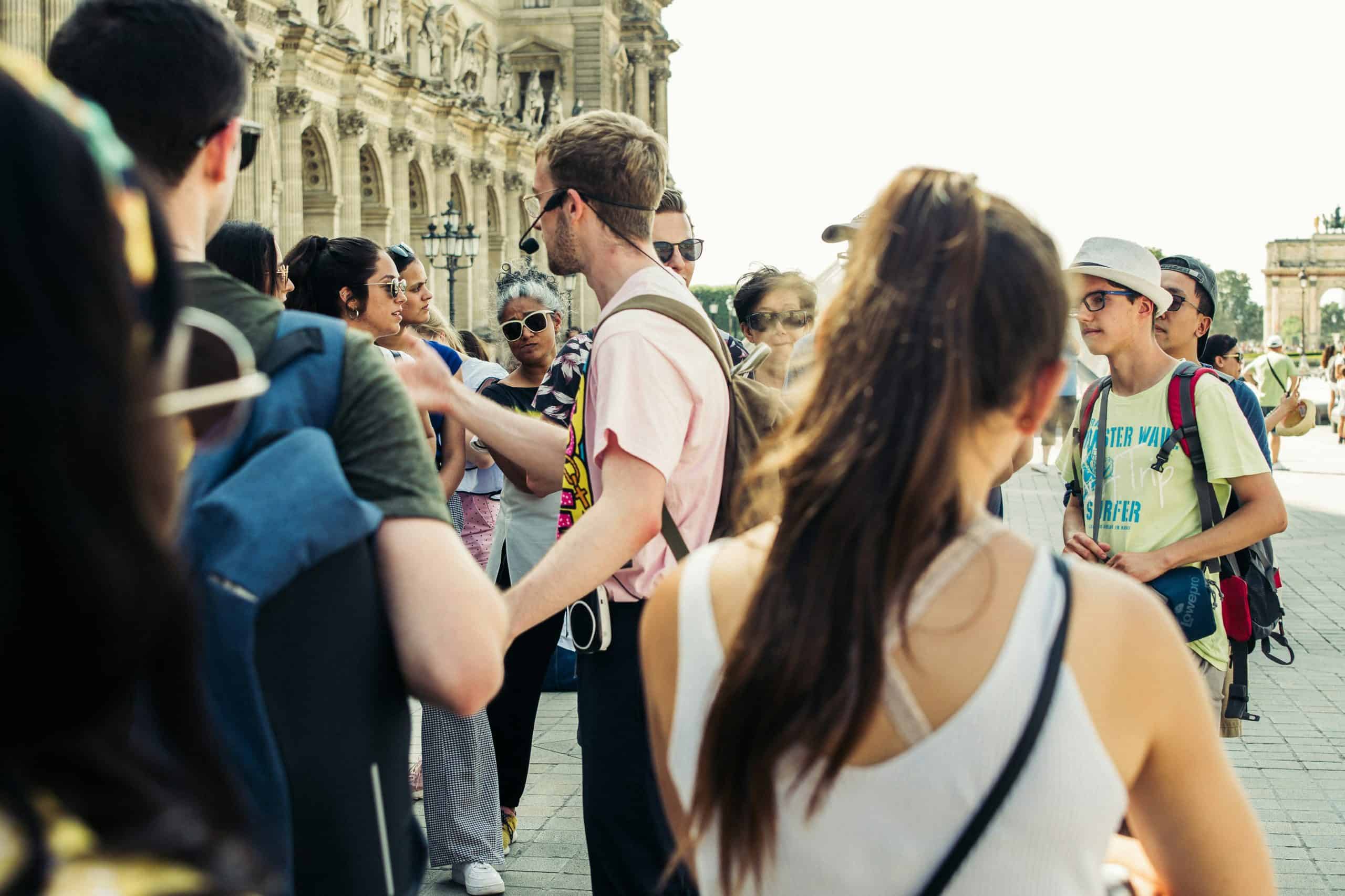 In person walking tour showing a guide with a microphone directing a group of tourists visiting a destination