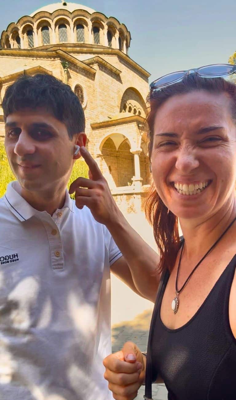 Two travelers sharing air pods to listen to the Sofia audio walking tour on VoiceMap