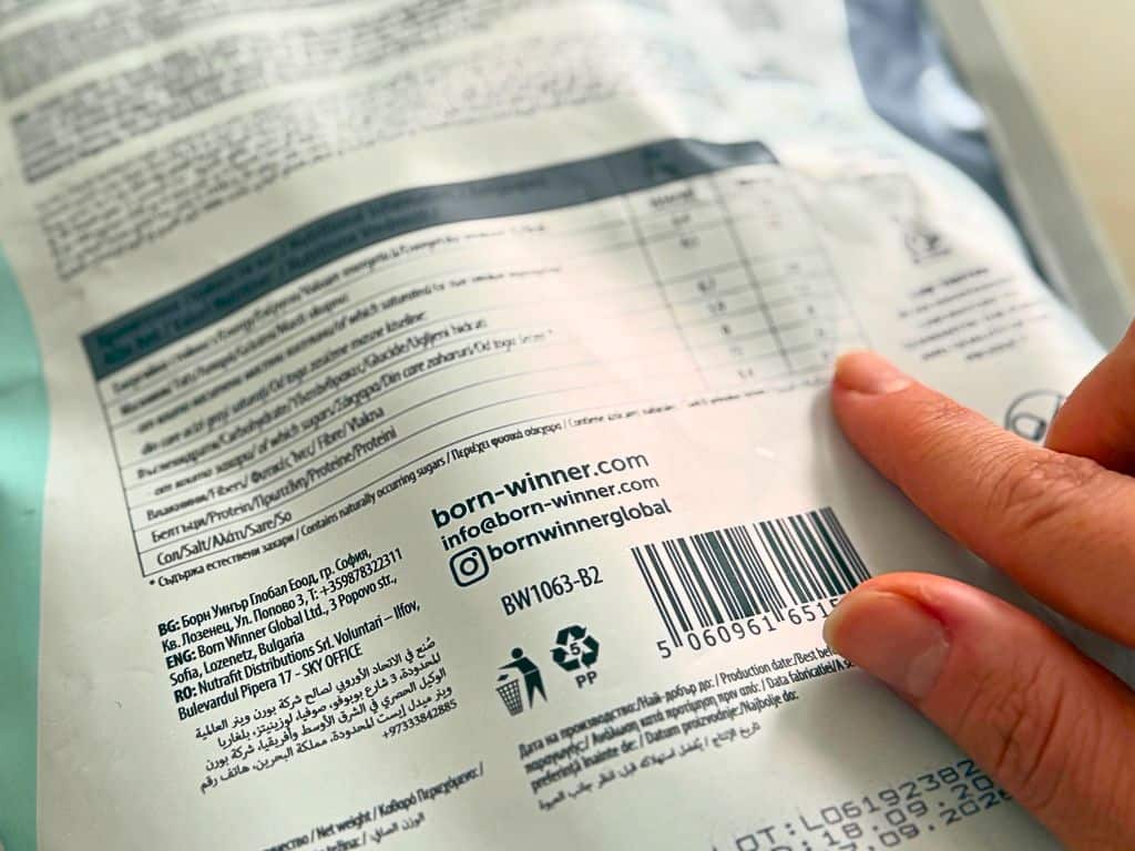 Backside of a food product packaging and a finger pointing at the nutritional label