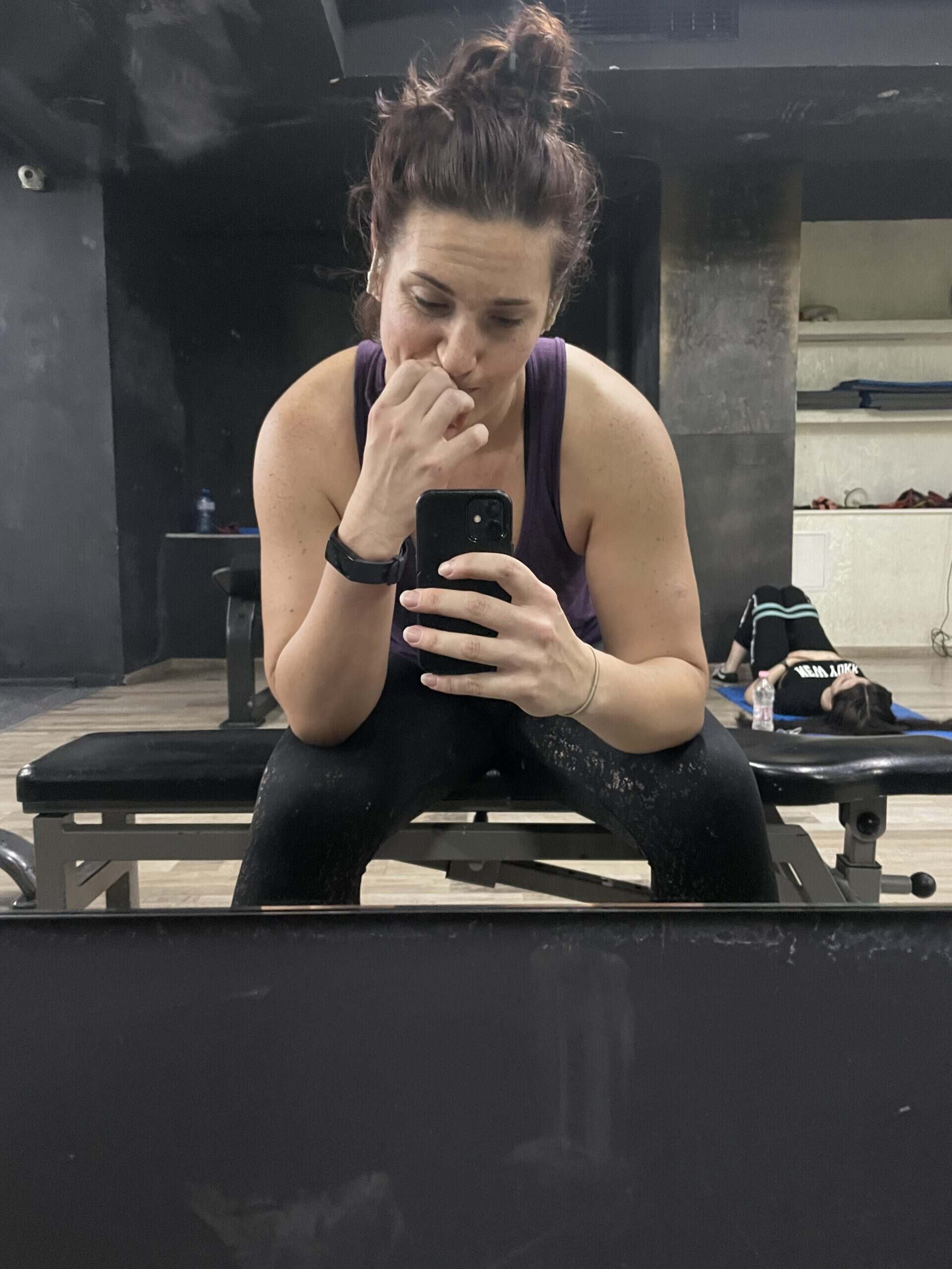 Heidi sitting at gym, resting with head in her hand